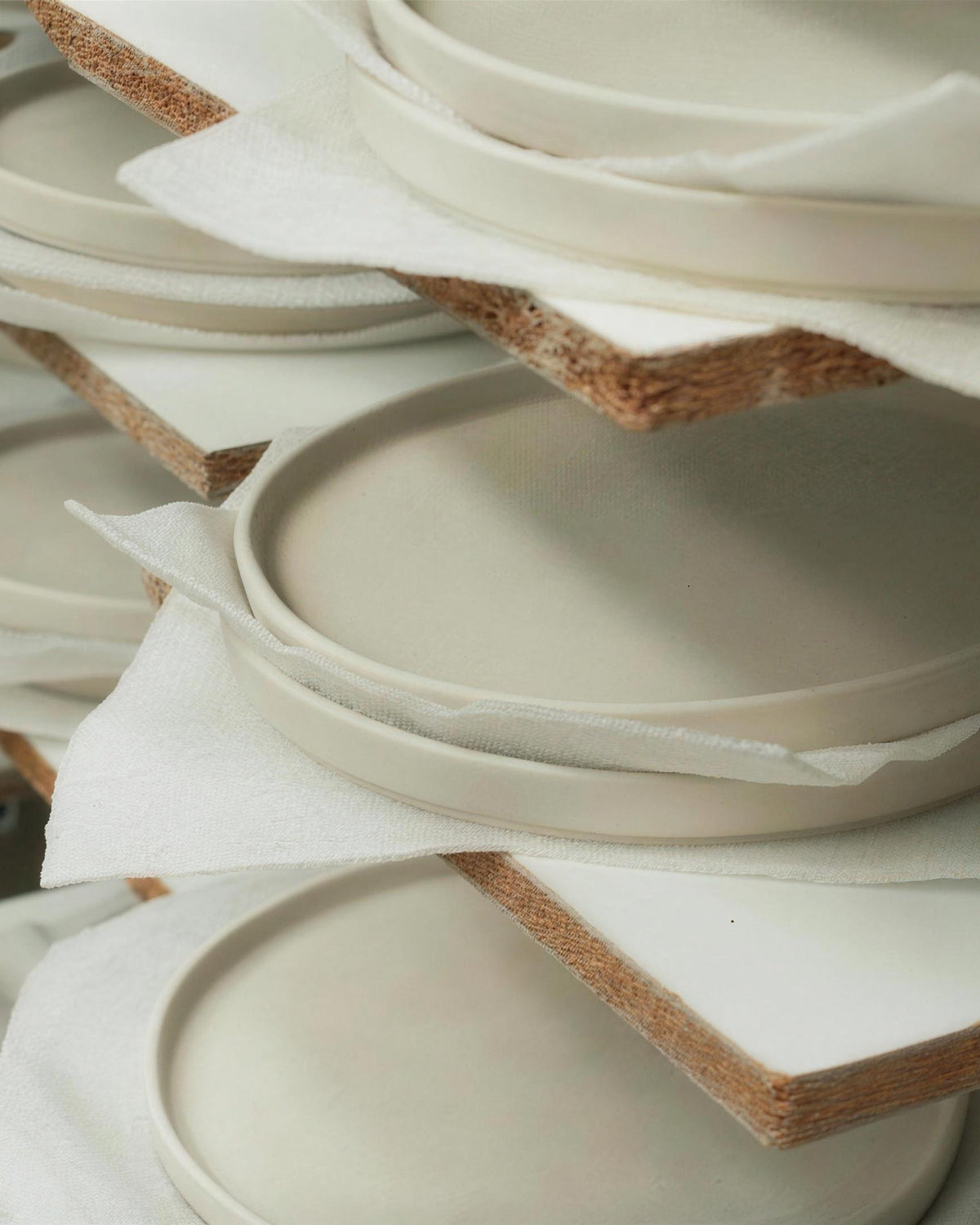 Unfired plates drying on boards in the workshop